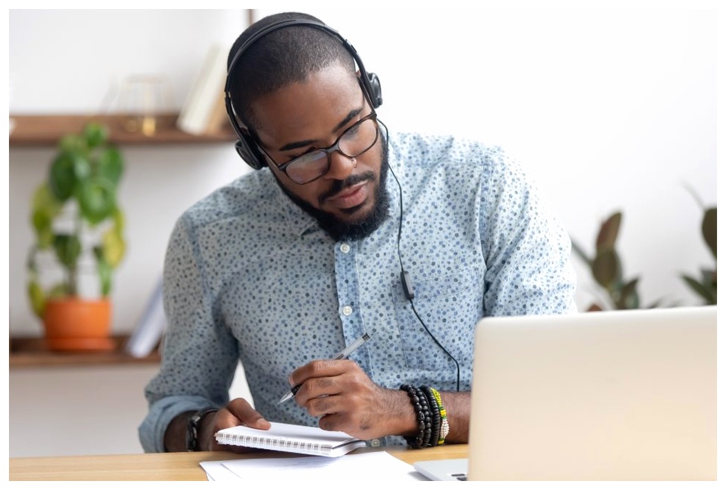 Man studying at computer with headphones